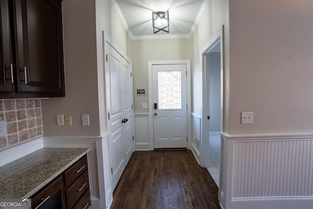 doorway with crown molding and dark hardwood / wood-style floors