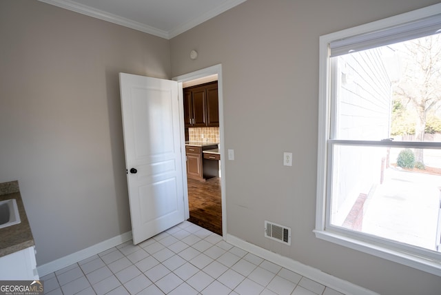 tiled empty room featuring ornamental molding