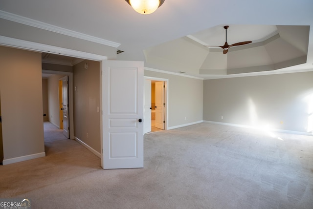 carpeted spare room with ceiling fan, crown molding, and a raised ceiling