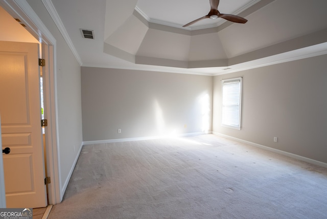 spare room featuring a raised ceiling, light colored carpet, ceiling fan, and ornamental molding