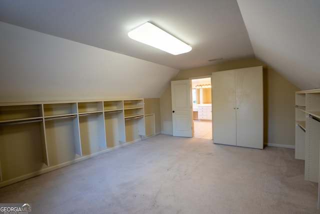 additional living space featuring vaulted ceiling and light carpet