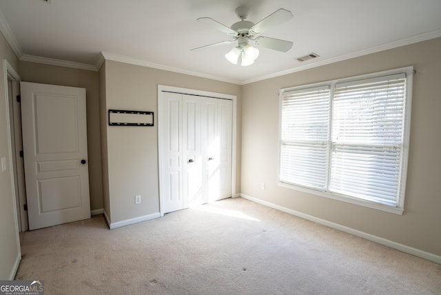 unfurnished bedroom with light carpet, a closet, ornamental molding, and ceiling fan