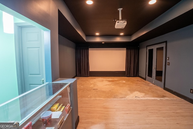 home theater with a tray ceiling and light hardwood / wood-style flooring