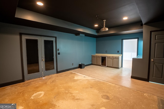 interior space with gray cabinetry, beverage cooler, and a raised ceiling