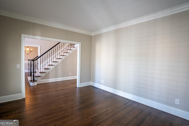 spare room with dark hardwood / wood-style flooring, crown molding, and a notable chandelier