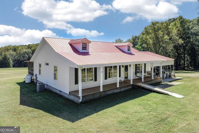 back of property with cooling unit, a lawn, and a porch