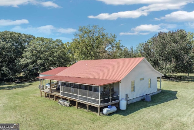 rear view of house featuring a sunroom, cooling unit, and a yard