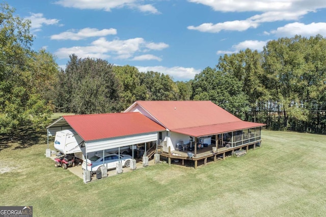 rear view of property with a yard, a sunroom, and a carport