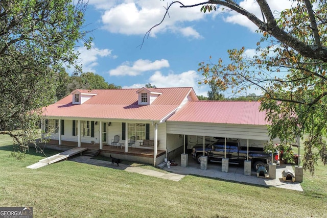 rear view of house with a porch, a carport, and a lawn