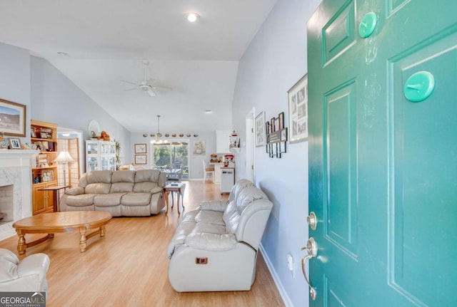 living room featuring light hardwood / wood-style floors, a high end fireplace, high vaulted ceiling, and ceiling fan