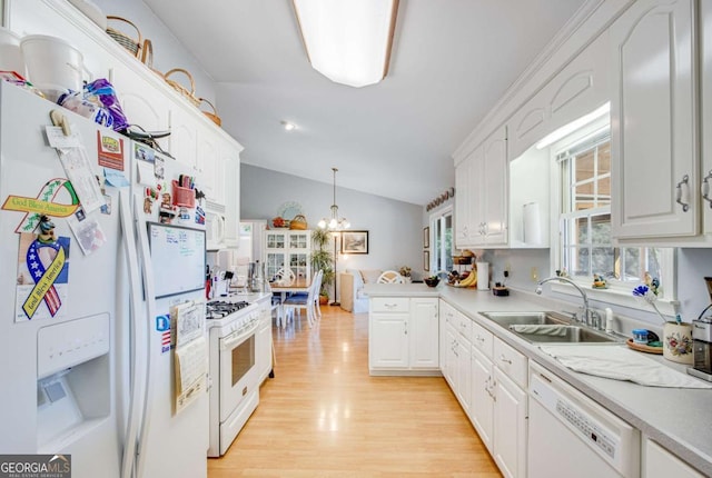 kitchen with white appliances, white cabinets, lofted ceiling, sink, and hanging light fixtures