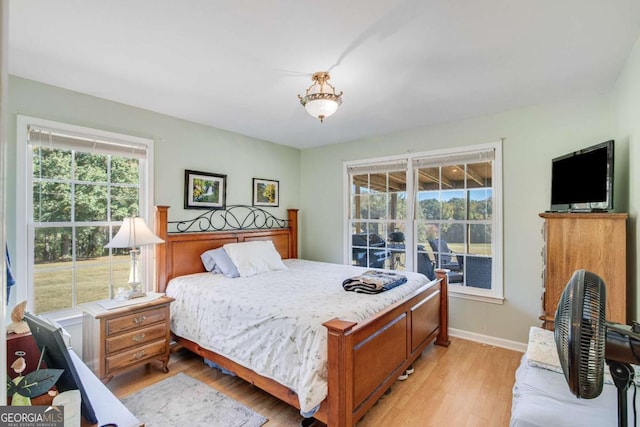 bedroom with light hardwood / wood-style floors and multiple windows