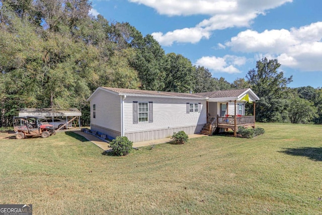 manufactured / mobile home with a front yard, a deck, and a carport