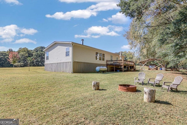 view of yard featuring a deck and a fire pit