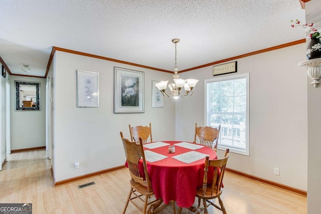 dining area with light wood-type flooring, a wealth of natural light, a chandelier, and a textured ceiling