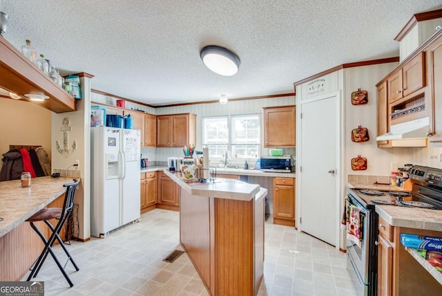 kitchen featuring a center island, sink, appliances with stainless steel finishes, a breakfast bar area, and ornamental molding