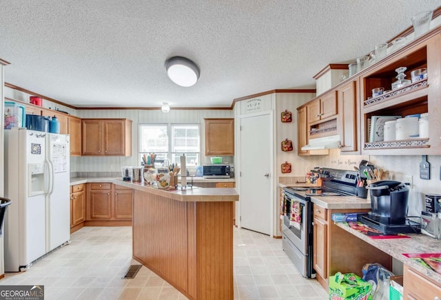 kitchen with a textured ceiling, appliances with stainless steel finishes, ornamental molding, and a kitchen island