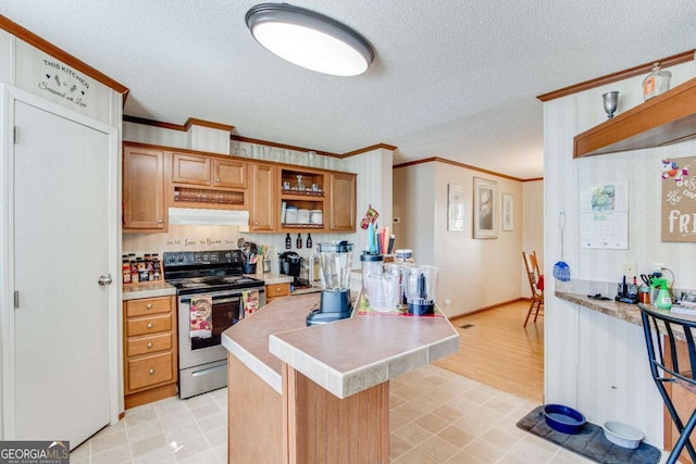 kitchen with a breakfast bar, a textured ceiling, ornamental molding, and stainless steel range with electric cooktop