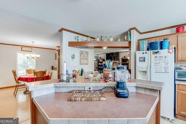 kitchen featuring pendant lighting, ornamental molding, a textured ceiling, and a kitchen island