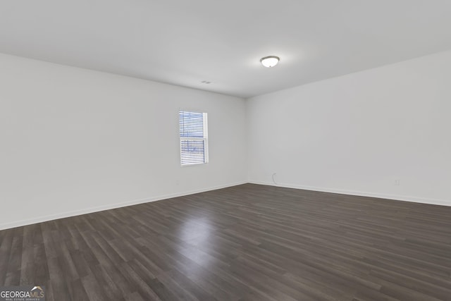 empty room with dark hardwood / wood-style flooring