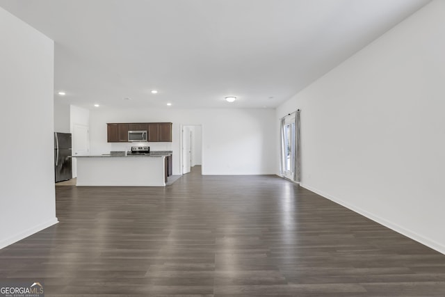 unfurnished living room featuring dark hardwood / wood-style floors and a barn door