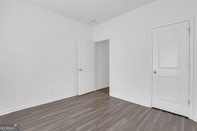 unfurnished bedroom with dark hardwood / wood-style flooring