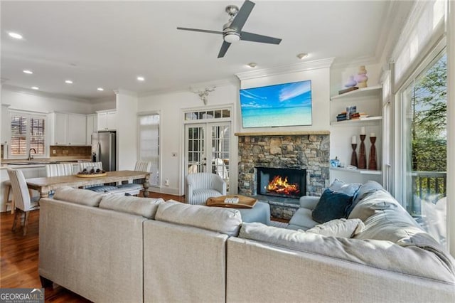 living room with french doors, a fireplace, sink, dark hardwood / wood-style floors, and ceiling fan