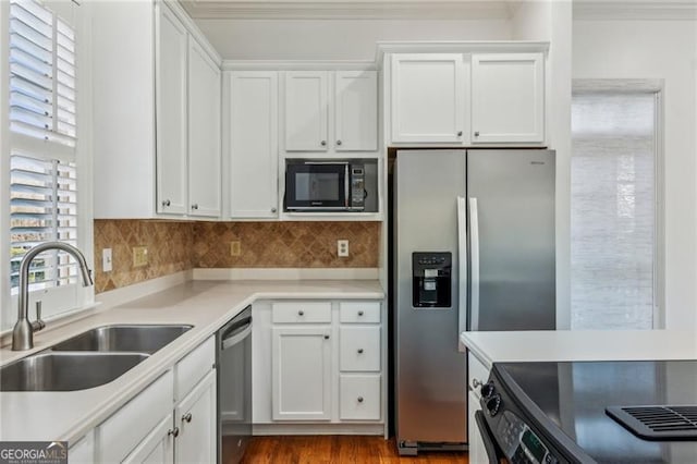 kitchen featuring plenty of natural light, sink, stainless steel appliances, and white cabinetry