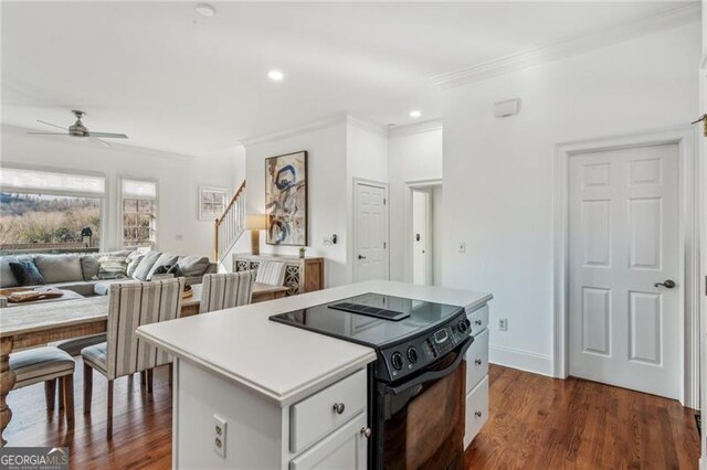 kitchen featuring white cabinetry, ceiling fan, dark hardwood / wood-style floors, a kitchen island, and black electric range oven