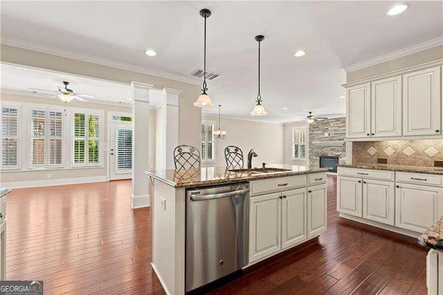 kitchen with decorative light fixtures, a kitchen island, stainless steel dishwasher, sink, and crown molding