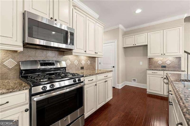 kitchen featuring crown molding, stainless steel appliances, white cabinets, dark hardwood / wood-style flooring, and stone countertops