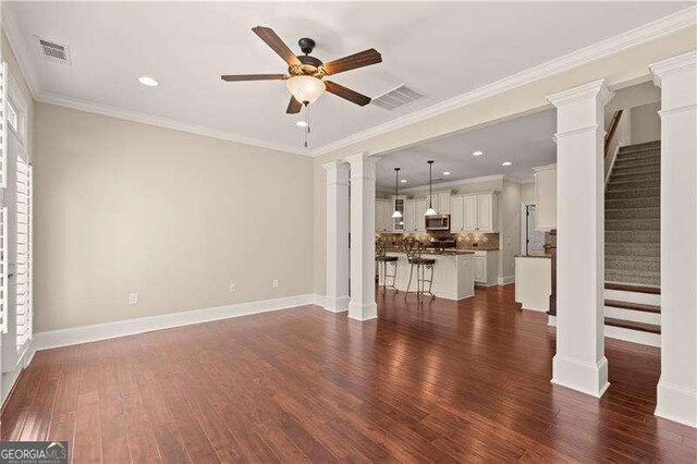 unfurnished living room with ceiling fan, dark wood-type flooring, and ornamental molding