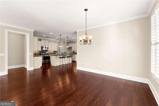 unfurnished living room featuring dark wood-type flooring, a wealth of natural light, and a notable chandelier