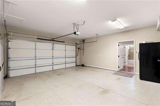 garage featuring a garage door opener and black fridge