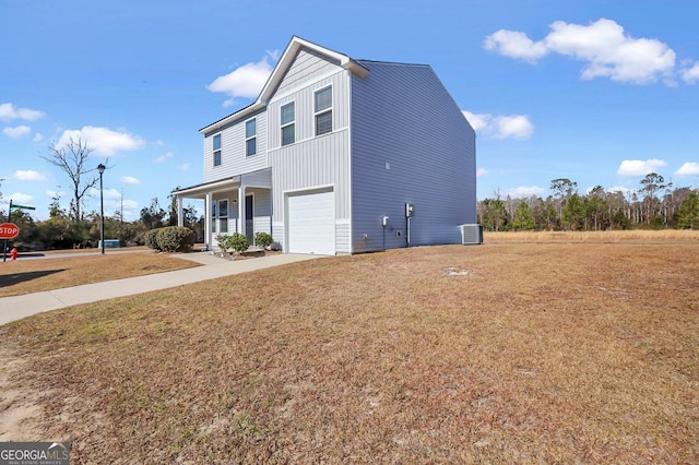 view of front of property with a garage, a front yard, cooling unit, and a porch