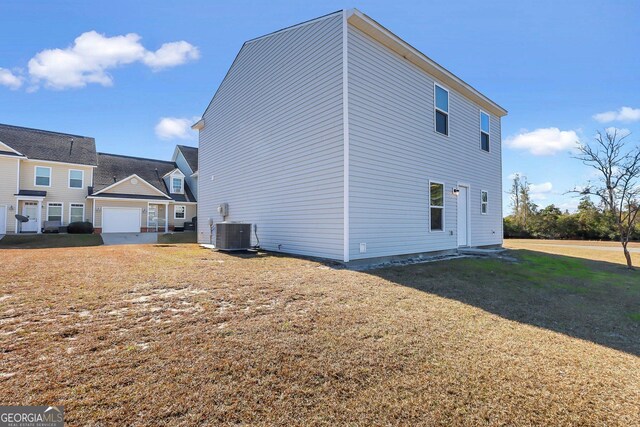 view of side of property featuring cooling unit and a yard