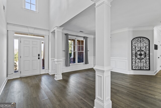 foyer featuring decorative columns and dark wood-type flooring