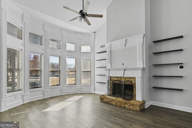 unfurnished living room with ceiling fan, dark hardwood / wood-style flooring, built in features, a fireplace, and vaulted ceiling