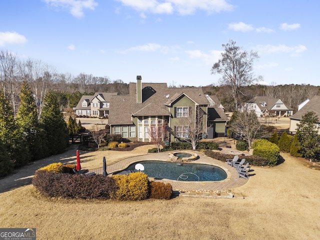 exterior space featuring an in ground hot tub