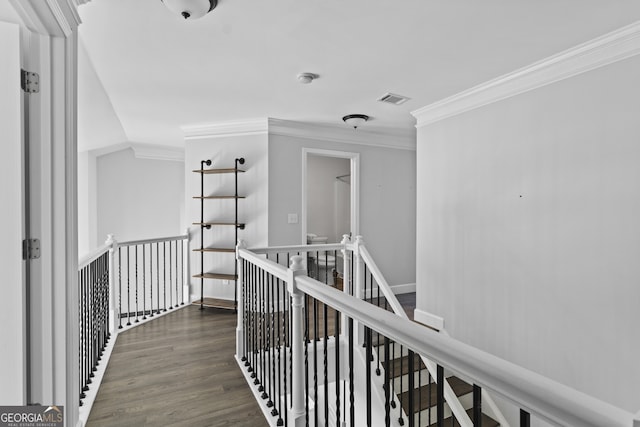 corridor featuring dark wood-type flooring, ornamental molding, and lofted ceiling