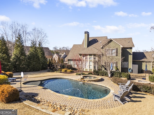 view of pool with an in ground hot tub