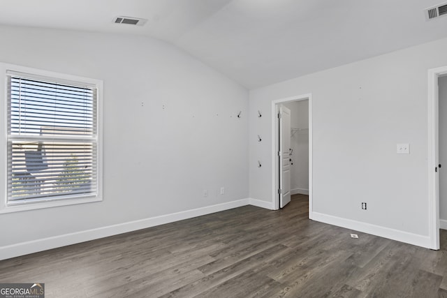 empty room with lofted ceiling and dark hardwood / wood-style floors