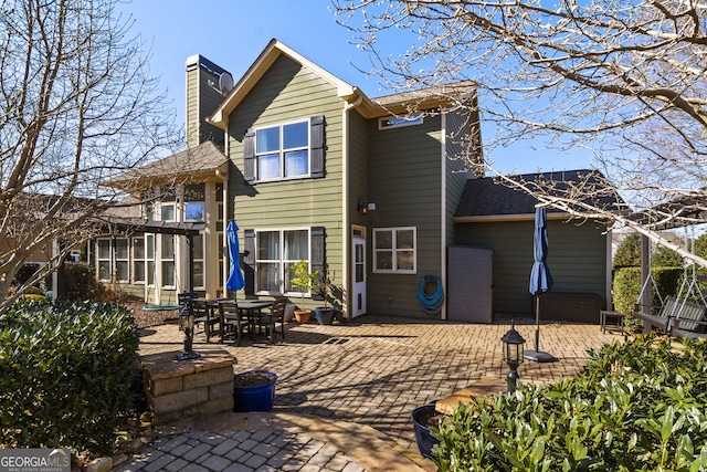 rear view of property with a pergola and a patio