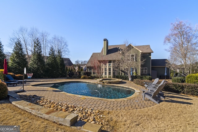 view of pool featuring a patio area and an in ground hot tub