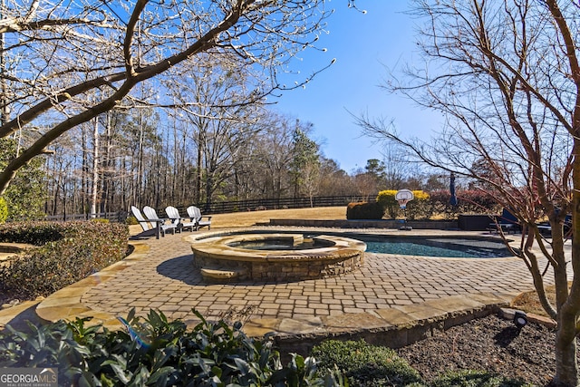 view of pool with a patio and an in ground hot tub