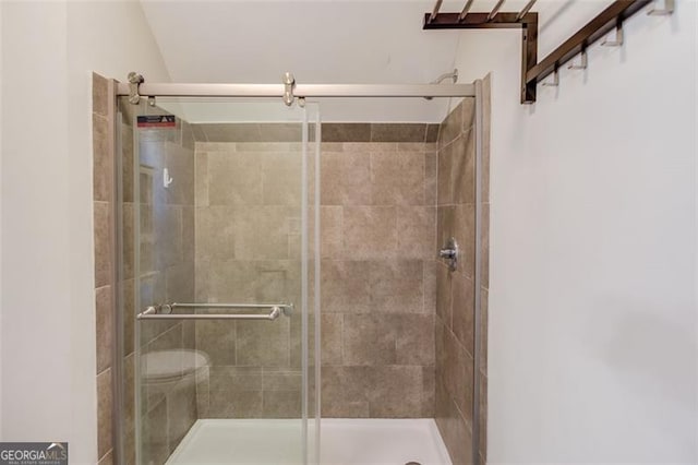 bathroom featuring an enclosed shower and toilet