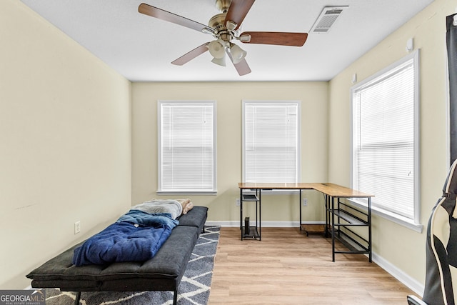 living area featuring ceiling fan, plenty of natural light, and light hardwood / wood-style floors