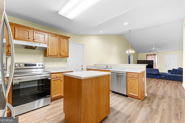 kitchen featuring appliances with stainless steel finishes, ceiling fan with notable chandelier, decorative light fixtures, and a center island