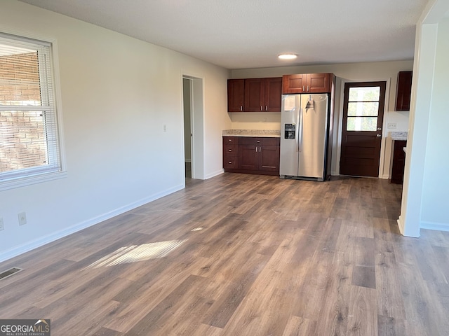 kitchen with stainless steel refrigerator with ice dispenser and wood-type flooring