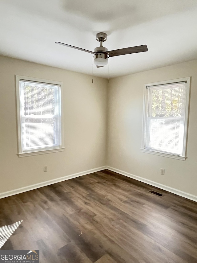 spare room with ceiling fan and dark wood-type flooring